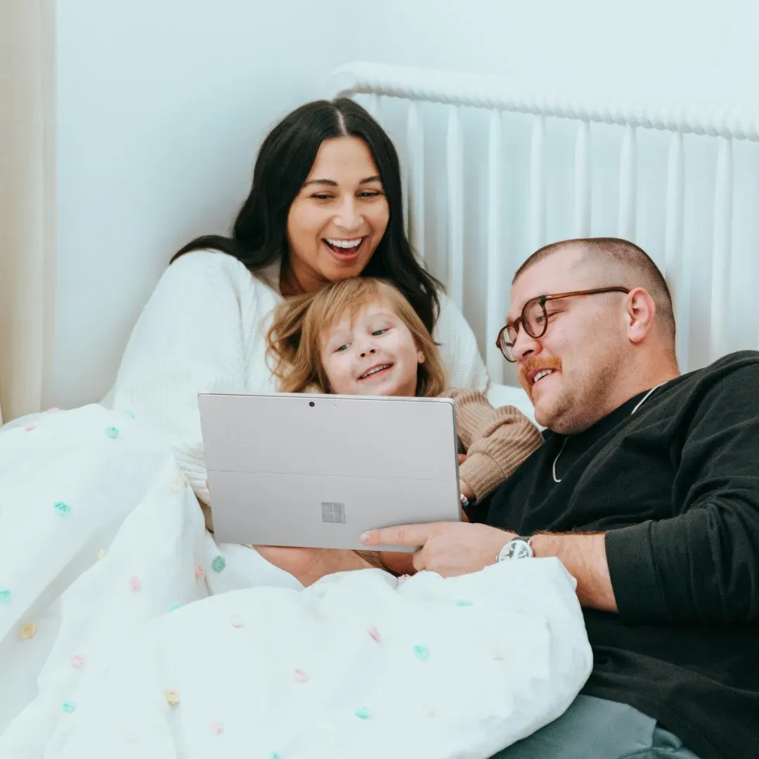 Family on laptop in bed